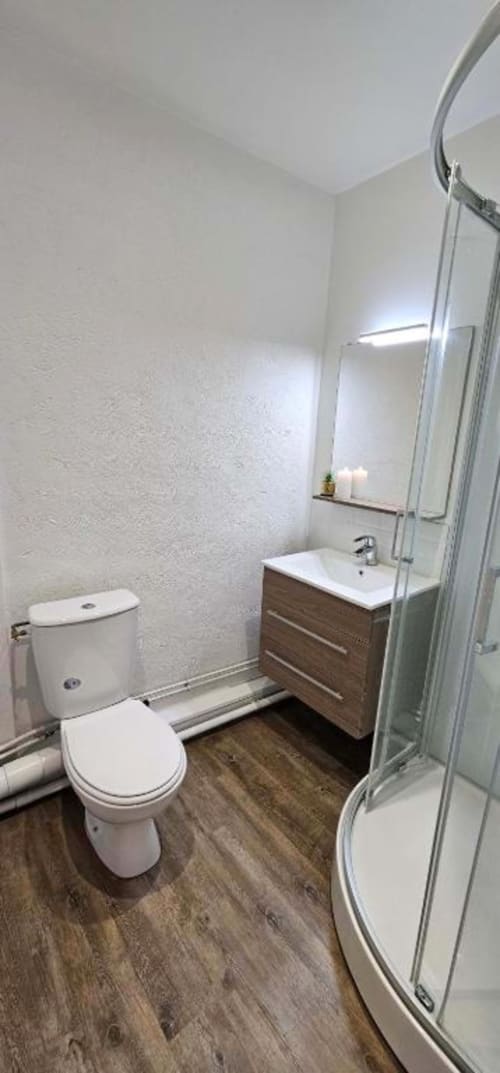 Salle de bain moderne avec douche, vasque, toilettes et carrelage blanc à l'appartement de Saint-Valery-en-Caux