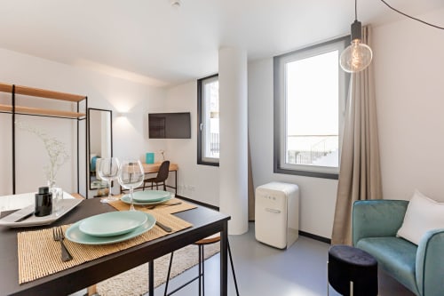 Estúdio moderno no Porto com área de refeições, cozinha compacta, cantinho aconchegante, janelas com vista para a cidade e decoração contemporânea