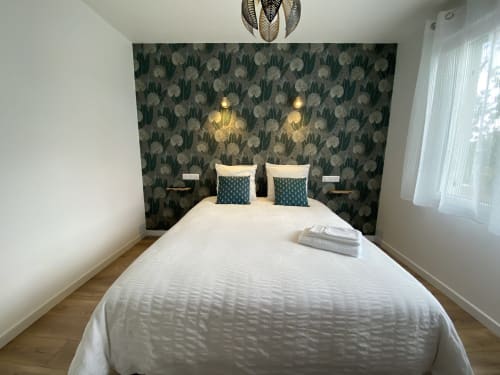 Chambre moderne à La Maison Blanche B&B, Bouguenais : lit blanc avec tête de lit à motifs foncés, oreillers turquoise, éclairage suspendu
