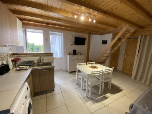 Cuisine ouverte et salle à manger avec poutres en bois au gîte Le Cocon De Curson, Chanos-Curson