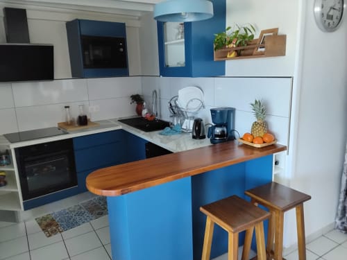 Cuisine moderne blanche et bleue avec bar en bois à l'appartement Kay Betty en Martinique