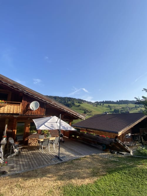 Chalet en bois de La Ferme des Georgières avec terrasse, parasol et vue sur les Alpes à Notre-Dame-de-Bellecombe