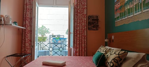 Luminosa habitación doble en Pensión Alicante San Nicolás con balcón, cortinas coral y mobiliario moderno en Alicante
