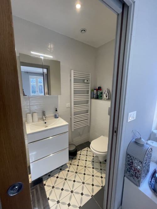 Salle de bains moderne à La Montagnette BnB à Moutiers avec vasque blanche, sèche-serviettes chauffant et carrelage géométrique