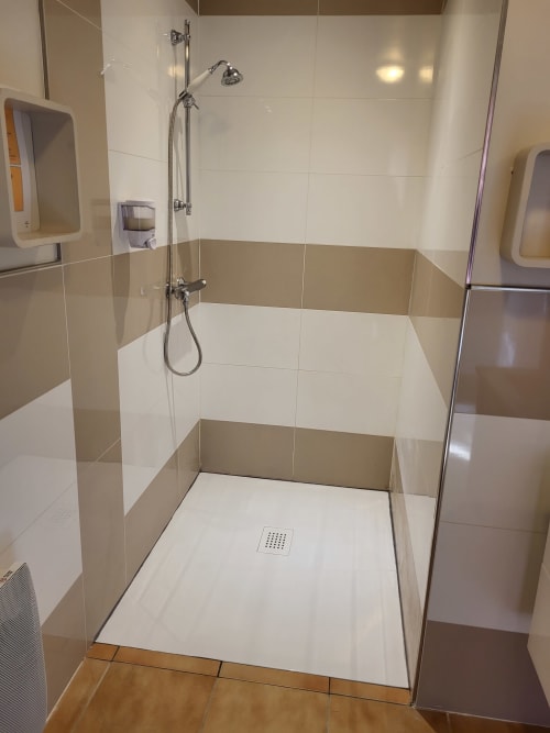 Douche spacieuse et moderne avec carrelage blanc, pommeau de douche cascade et paroi de verre à l'Hôtel Cheverny La Vie Est Belle