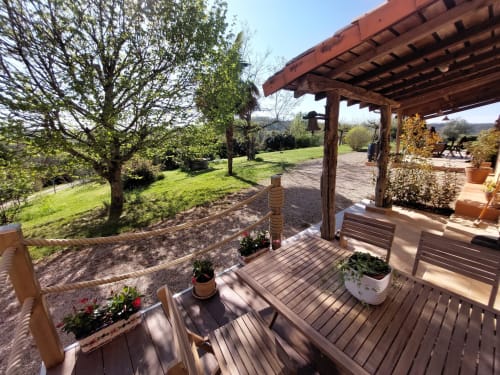 Wooden terrace with potted flowers overlooking green gardens at Les Gites de Campardon cottage in Monties