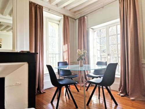 Modern dining area in Liberté Apartment at Villa République Normandie, Caen, with glass table, black chairs, and French doors