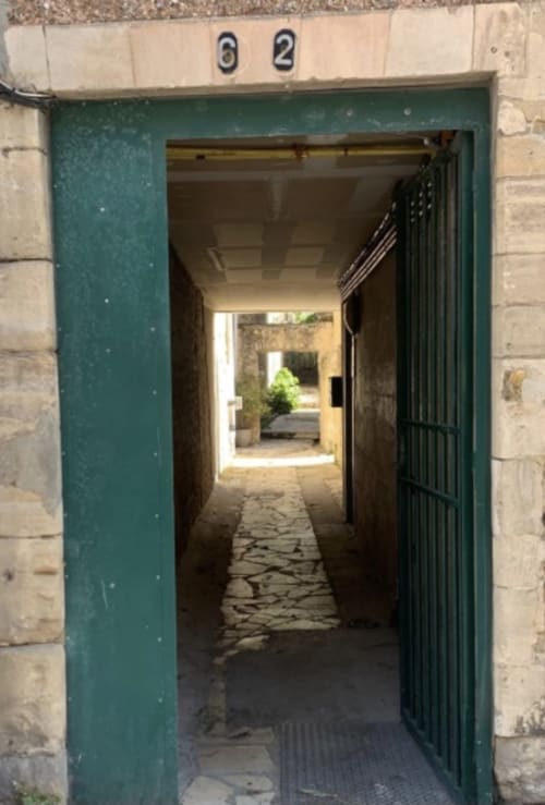 Porte d'entrée verte du Bayeux 58 menant au couloir avec cour intérieure