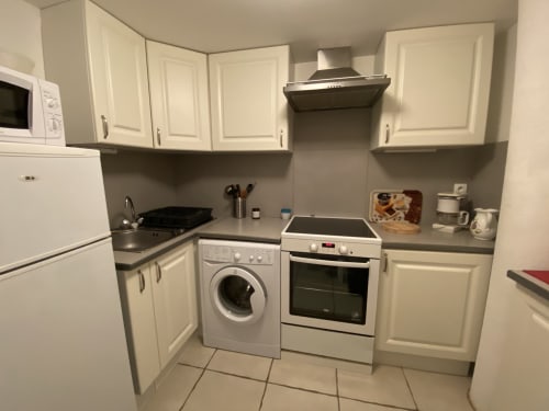 Cuisine compacte moderne au gîte Le Cocon De Curson à Chanos-Curson, France, avec mobilier blanc et électroménager inox
