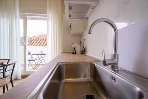 Cocina moderna con fregadero de acero inoxidable con vistas al monumento Alcazaba en Hotel Boutique Alcazaba Salobreña