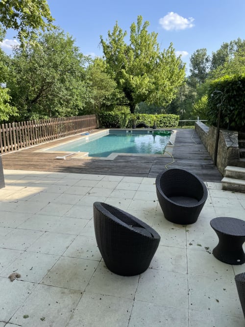 Piscine extérieure avec mobilier de terrasse aux Chambres d'hôtes Les Pratges à Figeac, entourée de verdure