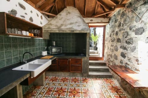 Cocina rústica en Casa 1820, Rural La Palma, con azulejos verdes, doble lavamanos, vigas de madera y piso decorativo