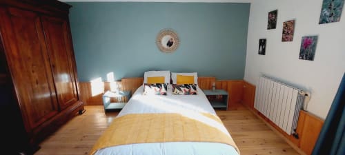 Bright bedroom in Les Gites de Campardon cottage, Monties, with queen bed, turquoise accent wall, wooden wardrobe, and garden