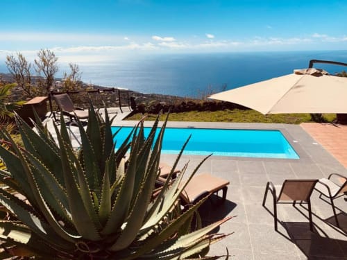 Villa de lujo con piscina privada con vistas al océano en Rural La Palma, El Pinillo, con plantas de agave y vistas al mar.