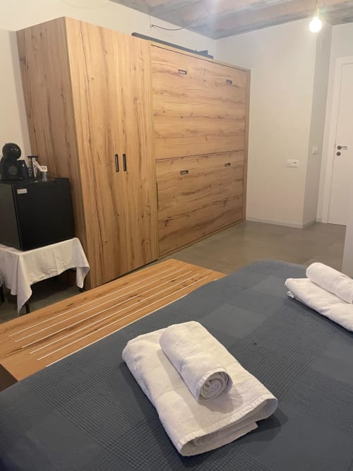 Habitació Cariñena a l'hostal boutique L'Algars de Tarragona amb armari de fusta i toalles enrollades