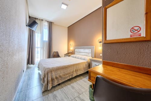 Habitación de no fumadores en Hostal El Molino con cama doble, escritorio, acceso a balcón y vistas a la montaña en Collado Villalba