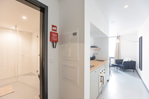 Moderno estúdio no hotel Porto com kitchenette, banheiro e sala de estar com design contemporâneo e vista para a cidade