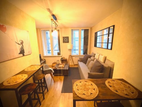 Salon cosy du Paillot de Montabert à Troyes avec canapé, coin repas et vue sur la ville