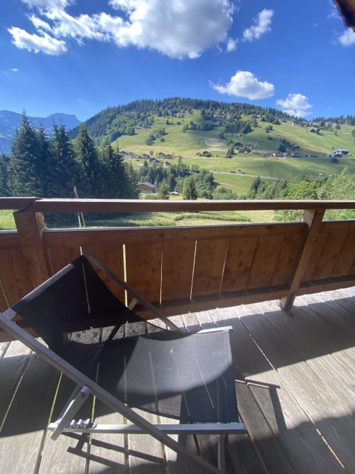 Balcon en bois avec chaises surplombant la vallée alpine et les montagnes à La Ferme des Georgières, Notre-Dame-de-Bellecombe