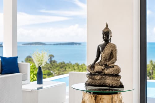 Buddha statue on wooden table overlooking sea view pool and Ko Samui coastline at Indigo Villa Samui