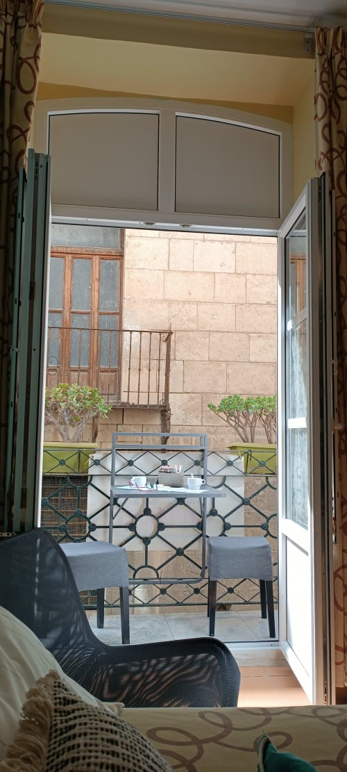 Vista del balcón de la habitación doble Pensión Alicante San Nicolás con vistas al patio interior, mesa y plantas