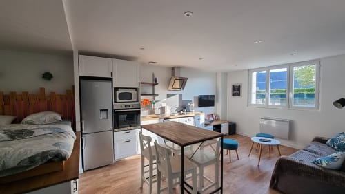 Studio apartment Ô LOCH in La Fôret-Fouesnant with kitchen, dining area, bed, and waterfront views