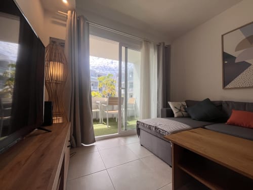 Modern apartment bedroom at FTV Holidays Homes in Corralejo with balcony access, smart TV, and comfortable seating area