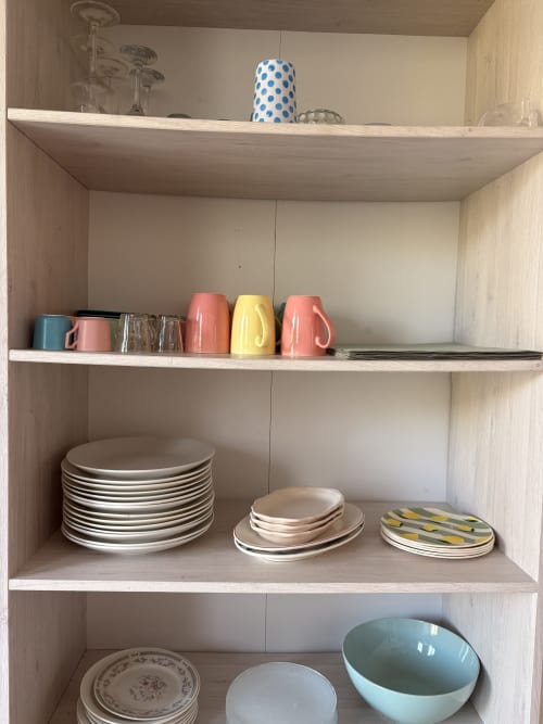 Meuble de cuisine en bois présentant de la vaisselle, des tasses colorées et de la dinnerware à La Villa Maraloupia, Les Avirons