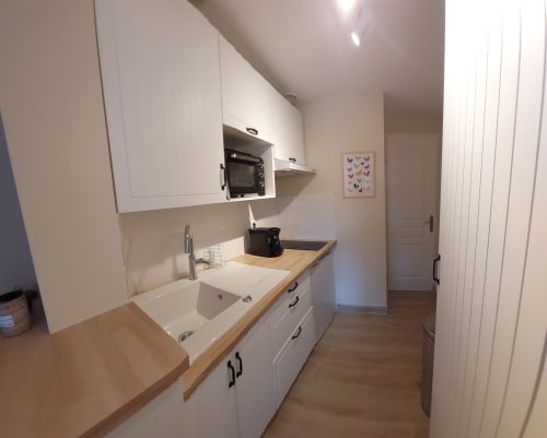 Modern kitchenette in Sunflowers and Poppies cottage at Les Gites de Campardon with white cabinetry, wooden countertops, and