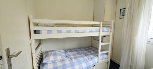 Lit superposé blanc avec literie à carreaux bleus dans l'appartement Mer et Maisons, La Trinité sur Mer