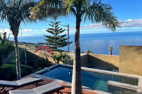 Piscina privada de La Gorona con vista al mar, La Palma. Palmeras, tumbonas, horizonte de mar azul.