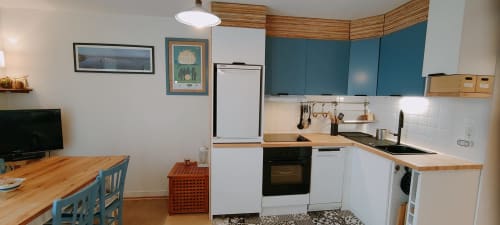 Cuisine moderne avec armoires teintes, électroménagers blancs, comptoirs en bois et salle à manger à Mer et Maisons, La Trinité