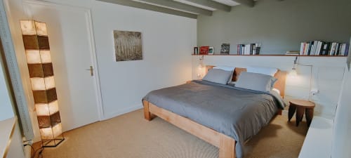 Chambre moderne à la villa Mer et Maisons à La Trinité-sur-Mer avec lit en bois, literie grise, étagères murales et ambiance apaisante
