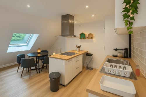 Cuisine ouverte et salle à manger modernes dans l'appartement Nid douillet à Saint-Valery-en-Caux avec puits de lumière et îlot central