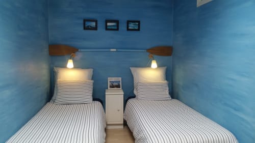 Deux lits jumeaux à literie rayée dans une chambre aux murs bleus chez Mer et Maisons, La Trinité sur Mer, décorée de style nautique