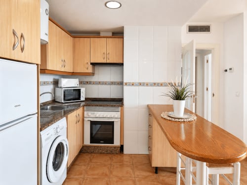 Modern kitchen in Apartamento Frontal Acuario at Apartamentos El Calón Playa, Cuevas del Almanzora, with wood cabinets, white