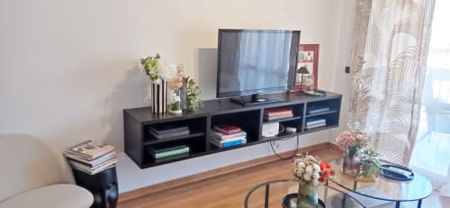 Sala moderna con TV de pantalla plana, consola negra, pisos de madera y vistas a la ciudad en apartamento True Home For You