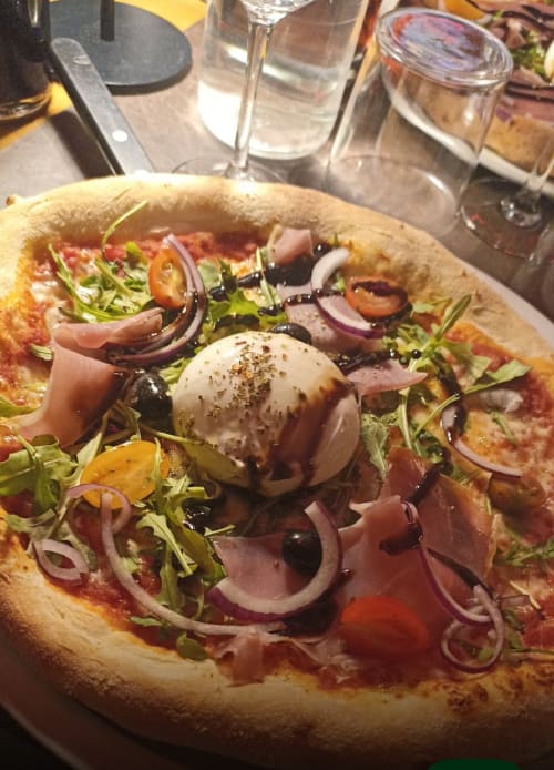 Pizza gastronomique au fromage burrata, prosciutto et roquette à La Montagnette à Moutiers, France