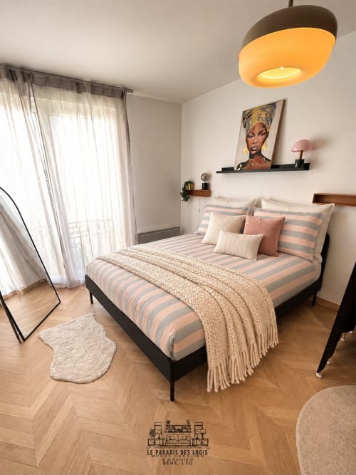 Chambre Cosy Luxe au Paradis Des Logis à Saint-Leu avec literie rayée, lampe suspendue et portes-fenêtres donnant sur balcon avec vue ville