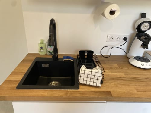 Kitchenette de l'Appartement 7 à La Maison Blanche avec évier noir, cafetière et comptoir en bois, Bouguenais