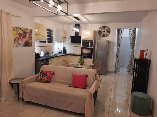 Appartement ouvert Kay Betty avec canapé beige, cuisine équipée, salle à manger et équipements modernes aux Trois-Îlets