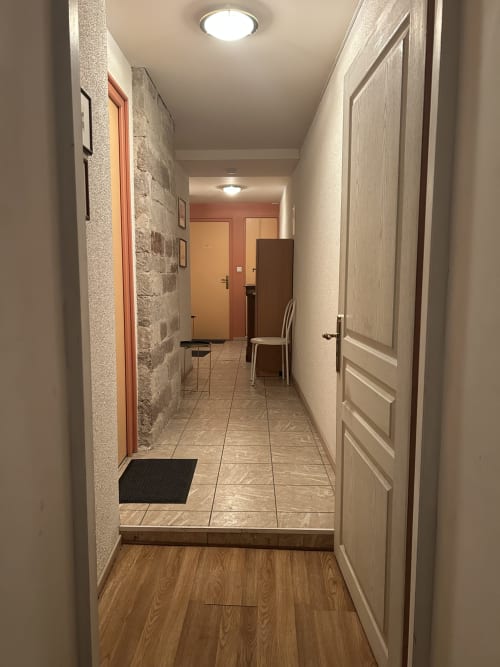 Couloir moderne de l'Hébergement Luxeuil Les Bains avec carrelage, murs crème et plusieurs portes