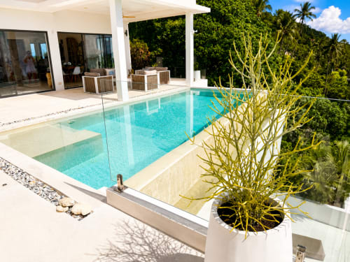 Luxury villa pool at Indigo Villa Samui with turquoise water, modern white architecture, and tropical jungle views in Ko