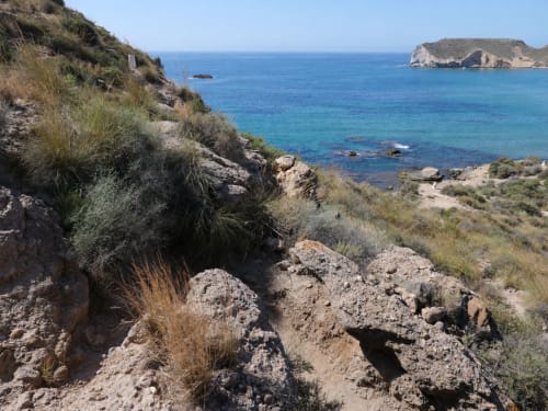 Rocky Mediterranean coastline with turquoise sea and island views near Cuevas del Almanzora, Spain