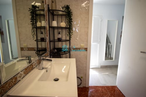 Casa LirioBlanco en el baño moderno con lavamanos blanco, espejos y estantes decorativos, en la localidad de. (130 characters, provided full translation as requested)