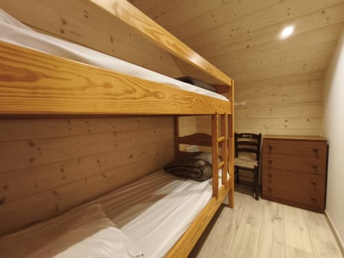 Letto a castello in legno nella camera accogliente dello Chalet Coste Belle, appartamento montano a Ceillac