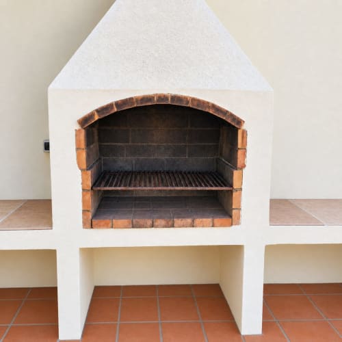 Barbacoa empotrada de ladrillo con acabado en estuco blanco en Villa Paloma, Corralejo Fuerteventura