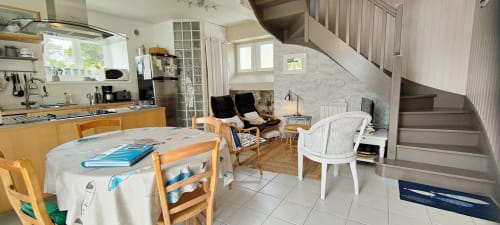 Cuisine ouverte sur le séjour avec mobilier en bois, coin détente et escalier à Mer et Maisons, La Trinité sur