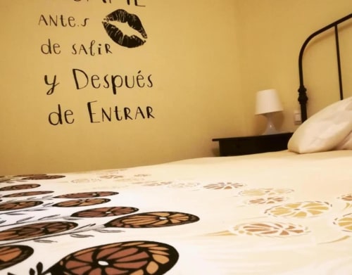 Dormitorio en Casas Rurales La Viña con vinilo decorativo español y ropa de cama floral en Cuzcurrita de Río Tirón