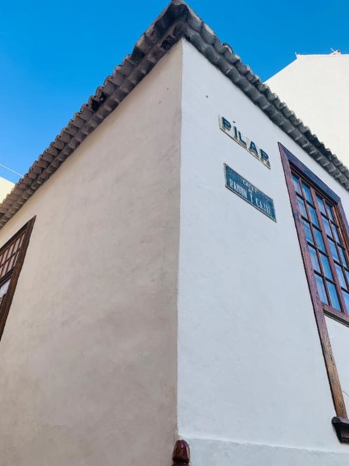 Fachada de Casa 1820 por Rural La Palma, edificio histórico encalado con ventanas de marco rojo en Santa Cruz de la Palma.